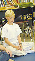 Young boy seated in meditation posture