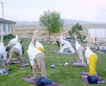 Nikki leading yoga postures class outside, with inmates